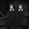 Chaux Ssettes Black socks by Hate Couture Clothing featuring white embroidered portrait with glasses and crossed shovels design, labeled โCHAUX-SSETTESโ, inspired by dark humor and true crime fashion.